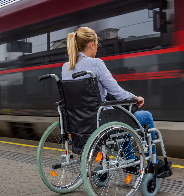 Žena na invalidnom vozíku na železničnom nástupišti.